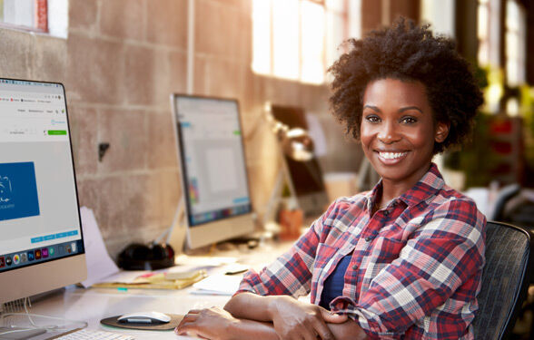 Graphic designer sitting behind her desk and smiling