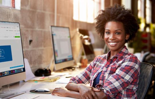 Graphic designer sitting behind her desk and smiling