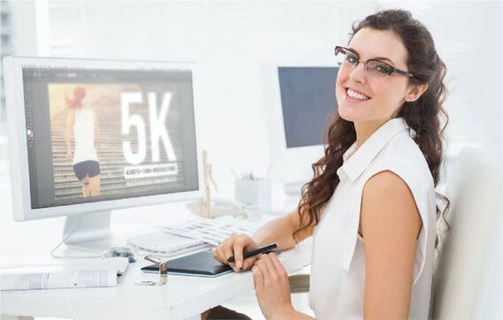 Graphic designer sitting behind her desk and smiling