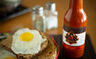 Roll-labels-bottle-of-hot-sauce